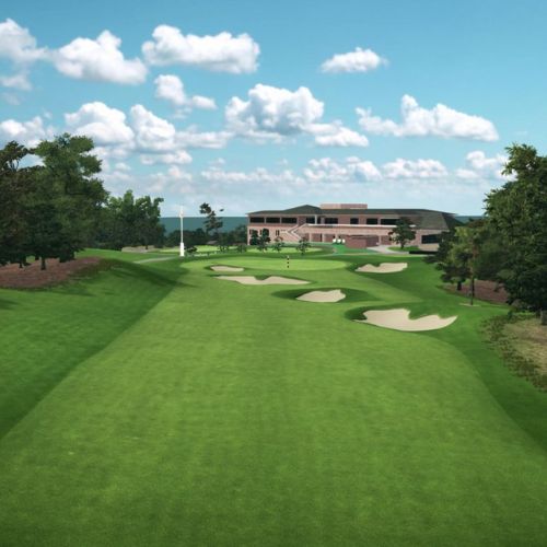 Keya Golf Club with green grass, bunkers, and a building under a blue sky with clouds.