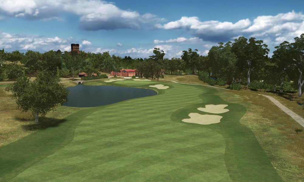 Golf course with green grass, trees, and a small pond under a blue sky.