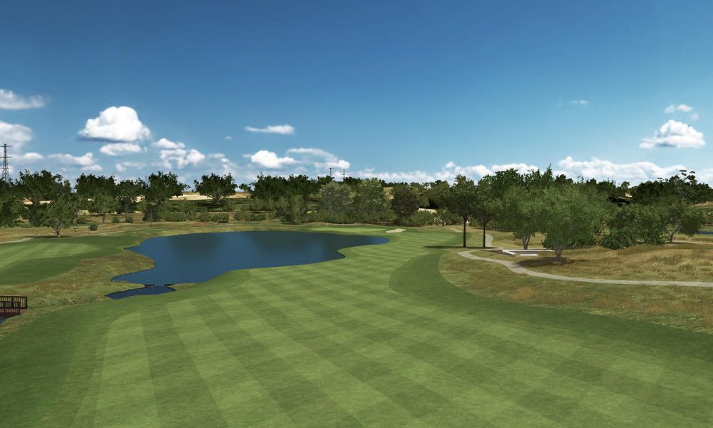 Golf course with a pond and trees under a blue sky