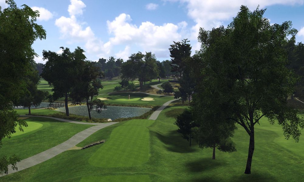 Golf course with green grass, trees, and a clear blue sky.