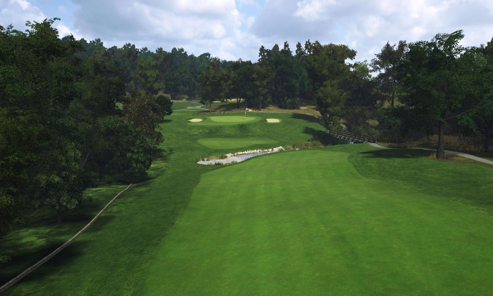 Golf course with green grass and trees under a cloudy sky