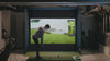Boy practicing on his golf sim in his garage